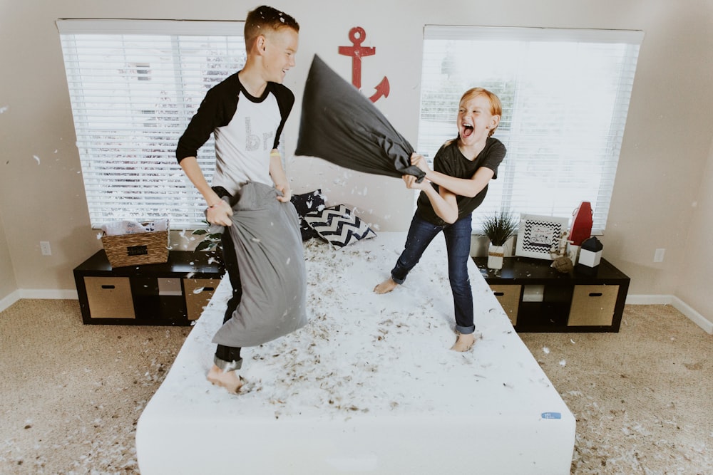 boy and girl having pillow fight