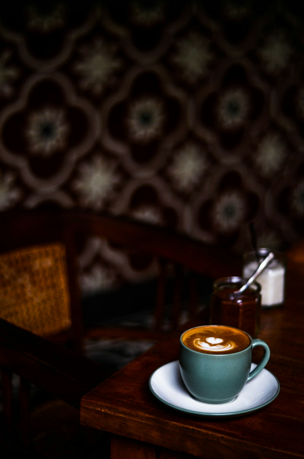 Fotografia de foco da xícara de café no molho no tampo da mesa
