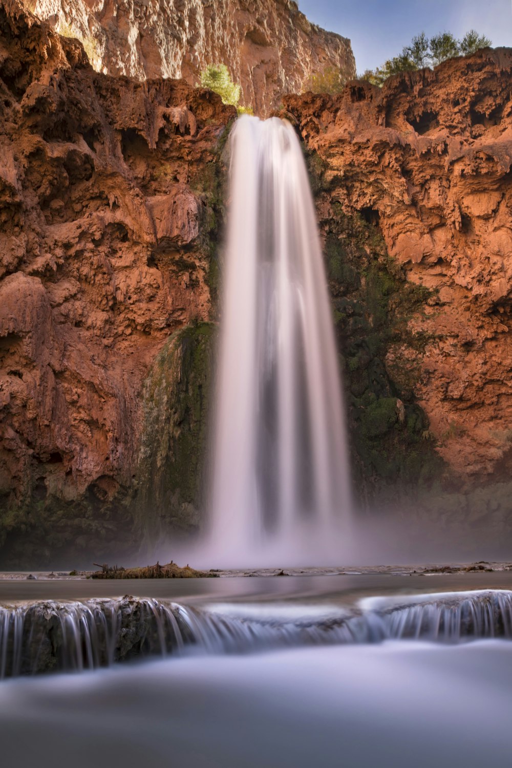 waterfalls between brown rock formation