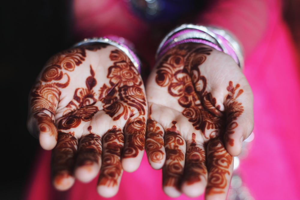 hand with black floral henna tattoos