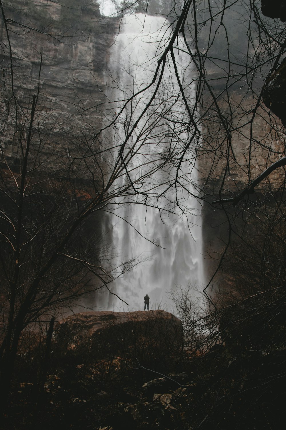 폭포 앞에 서 있는 사람