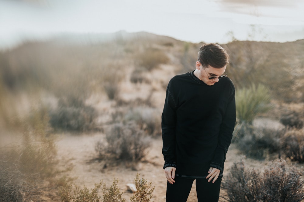 man standing while looking on ground during daytime