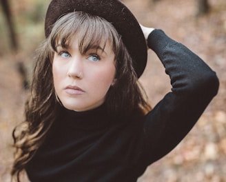 woman holding hat selective focus photography