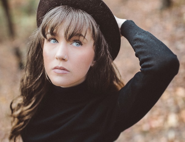 woman holding hat selective focus photography