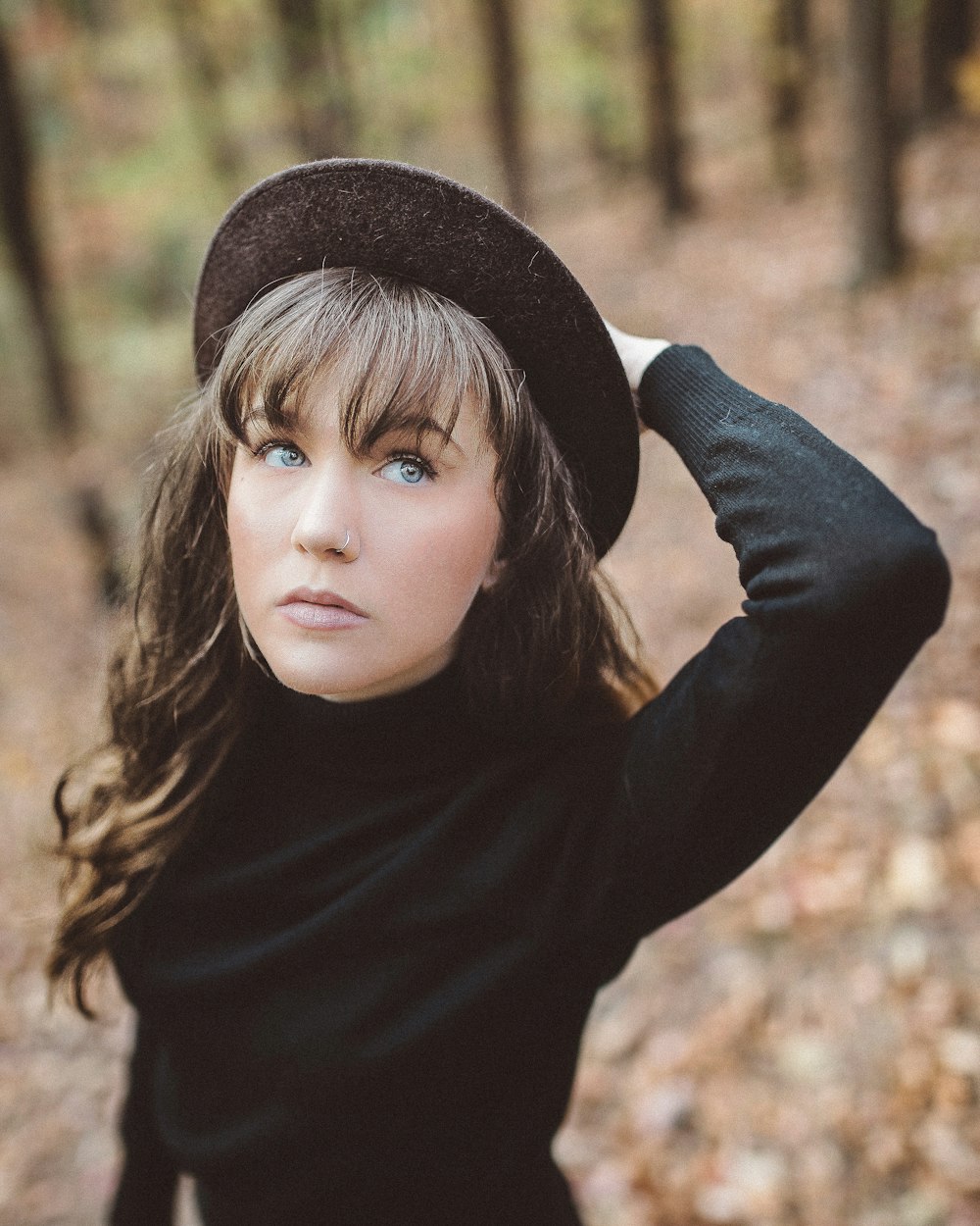 woman holding hat selective focus photography