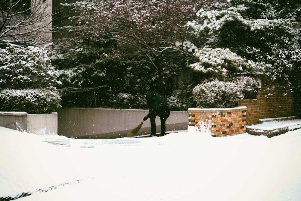 man holding broom stick near ledge