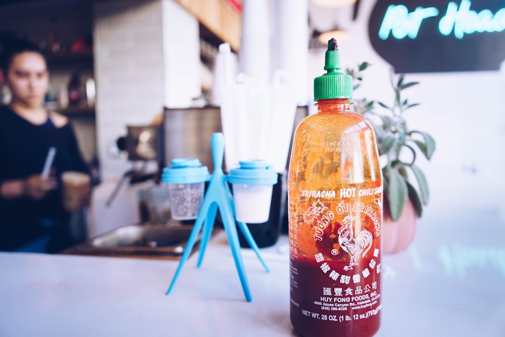 half-filled bottle beside cup rack