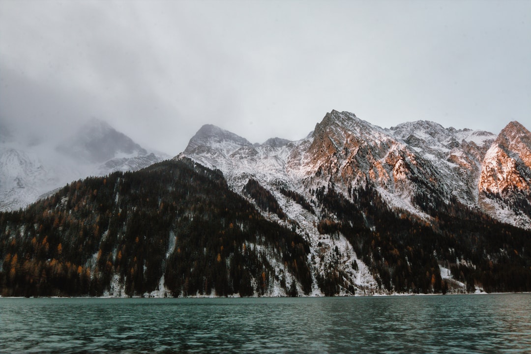 snow capped mountain near body of water