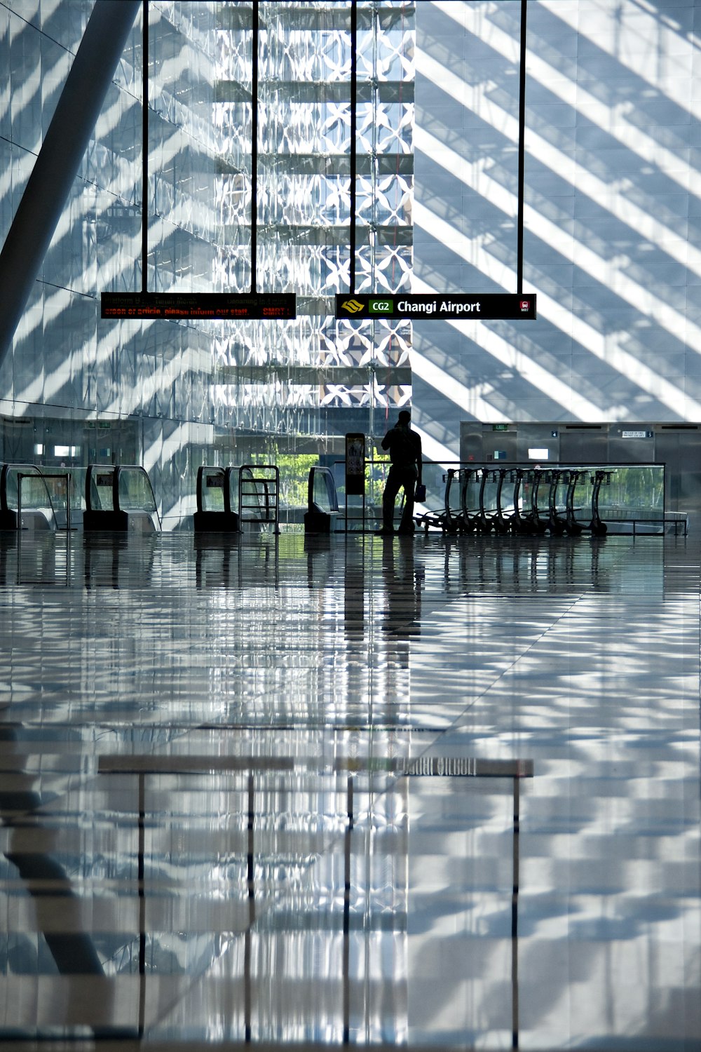 silhouette of man holding bag in inside of airport station during daytime