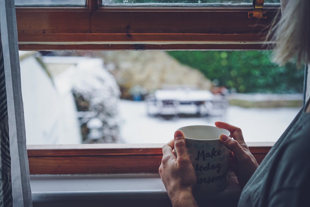 person holding white ceramic mug