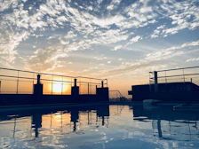 Sunset casting warm light over a sleek hotel pool area.