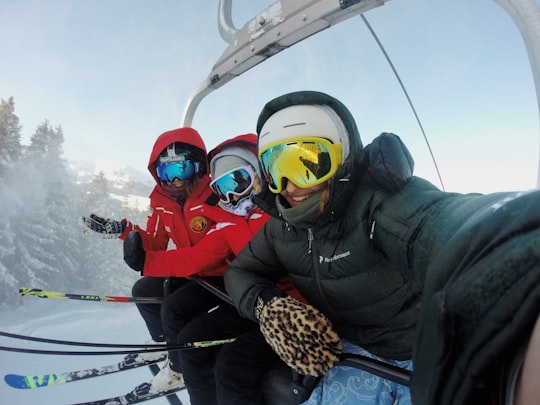 three person wearing ski gear riding cable car in Pila Italy