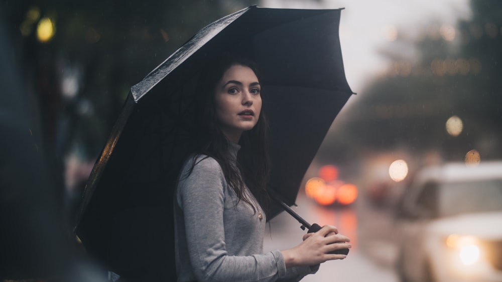 mujer en la calle sosteniendo paraguas