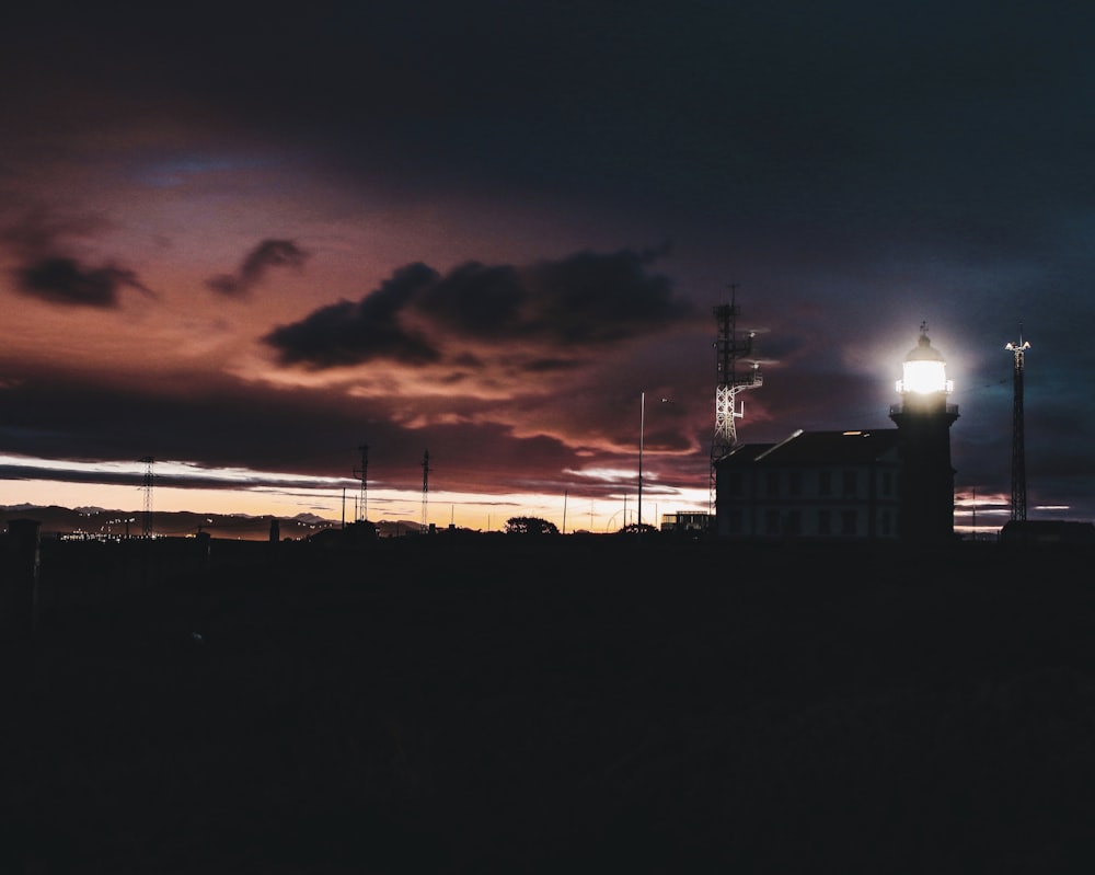 black lighthouse under brown and black sky