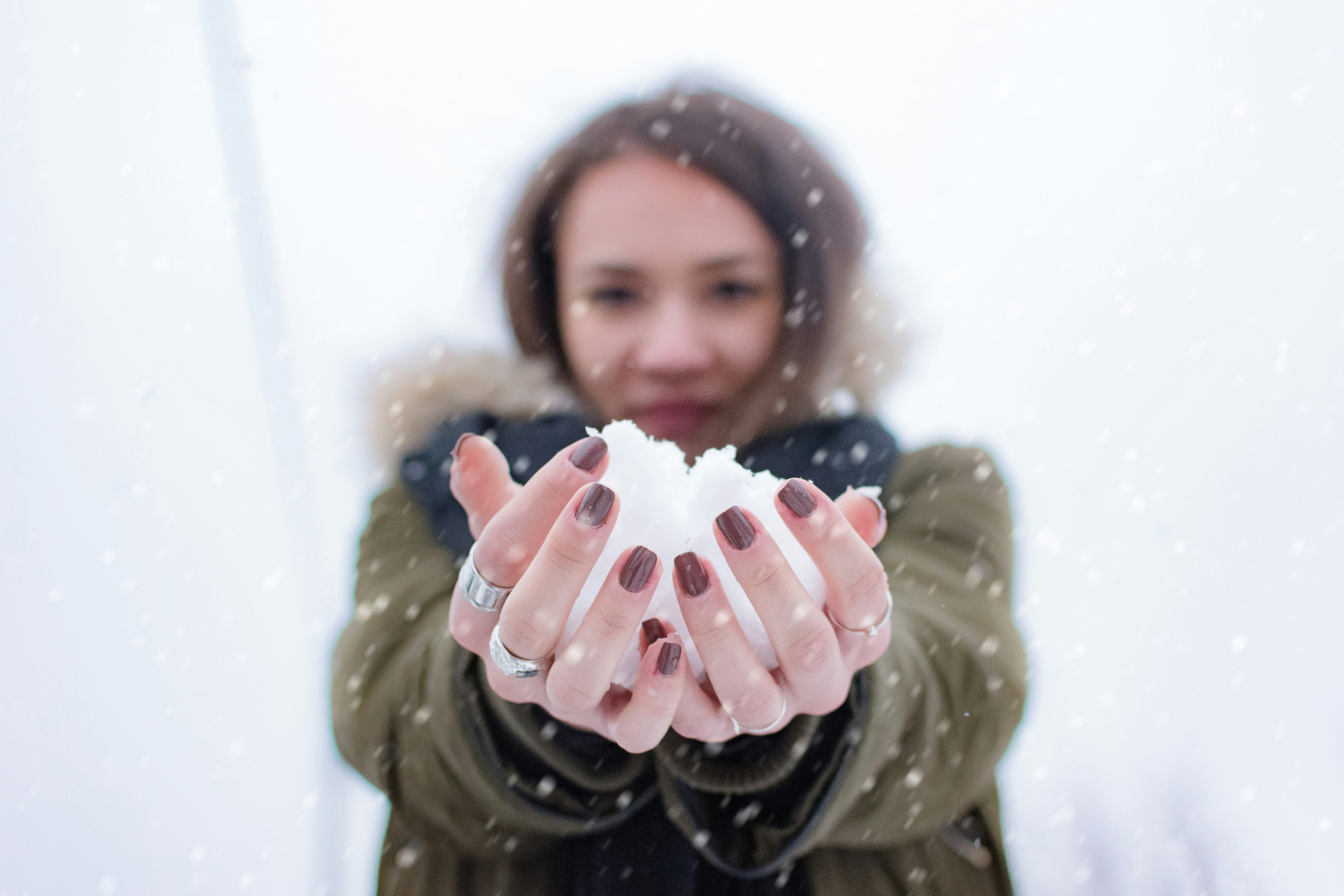 woman holding snow at daytime snowball teams background