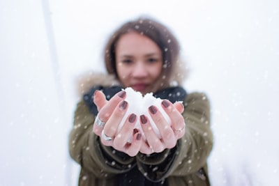 woman holding snow at daytime snowball google meet background