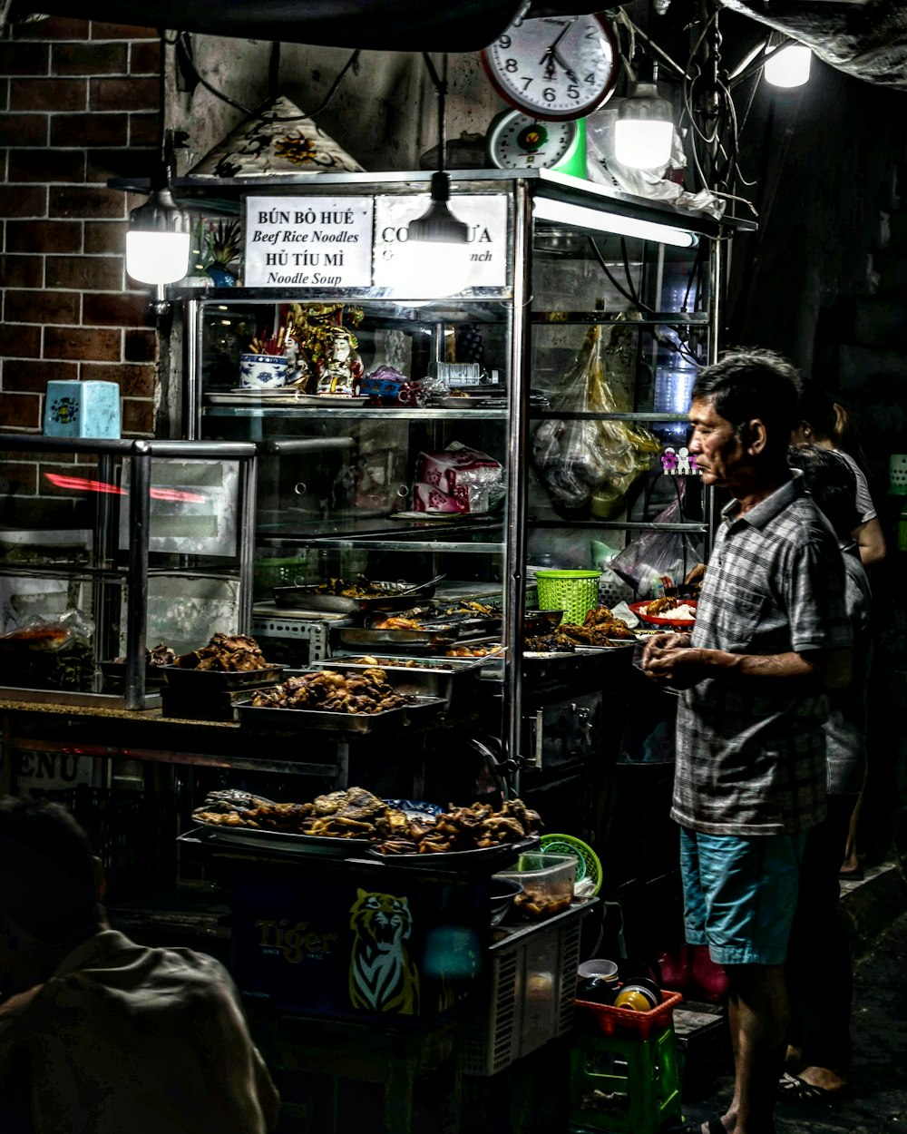 man wearing gray and black striped polo shirt while buying goods