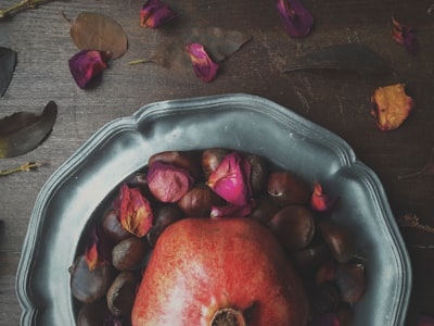 gray plate with flower petals chestnuts teams background