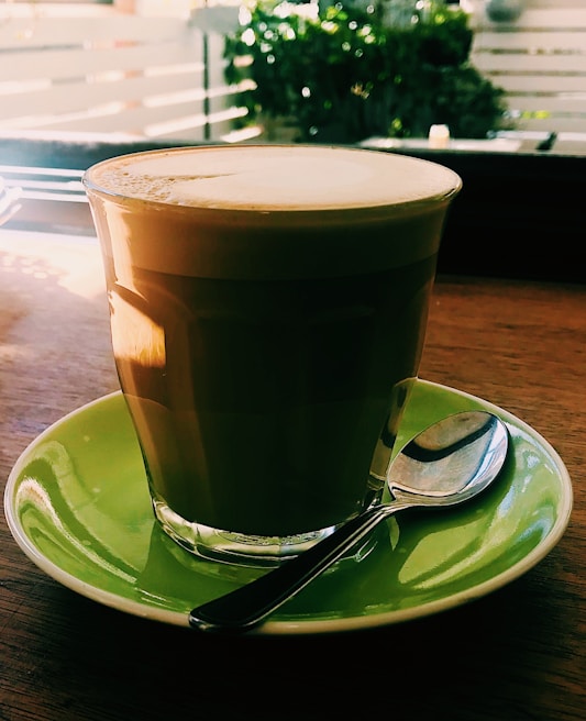 Bright morning light illuminating a glass of Awasso's energizing coffee drink with fresh herbs beside it