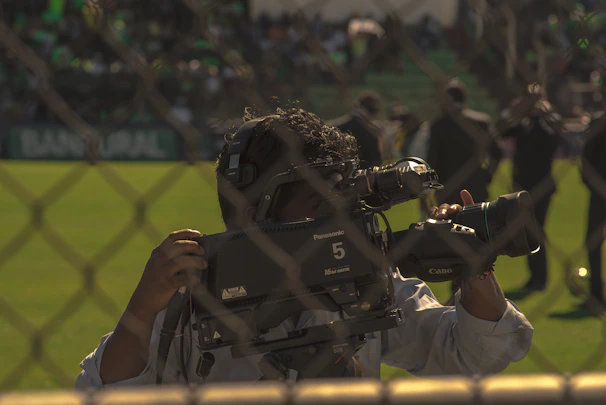Focused sports content creator filming a football training session with professional gear.
