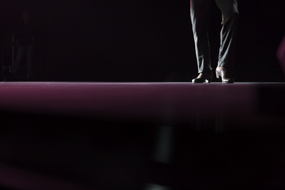 person in pair of brown leather formal shoes and black jeans