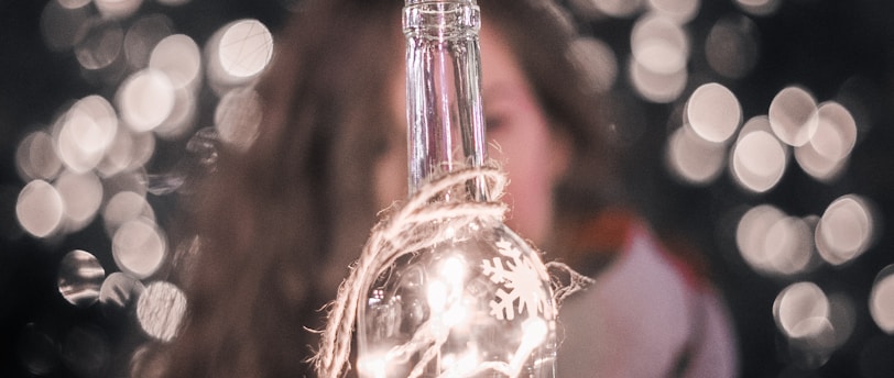 selective focus photography of string lights on bottle
