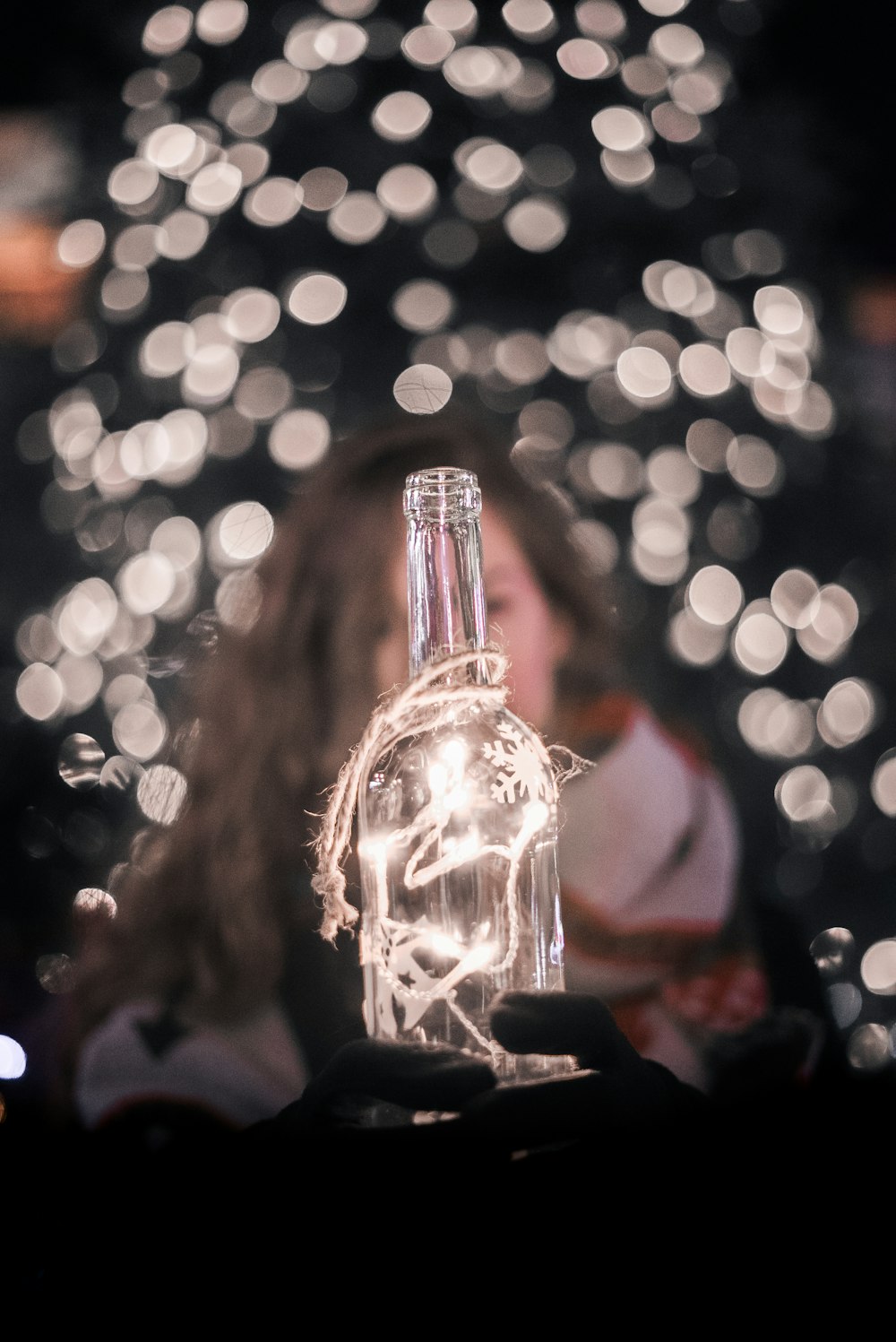 Photographie sélective de la mise au point des guirlandes lumineuses sur la bouteille