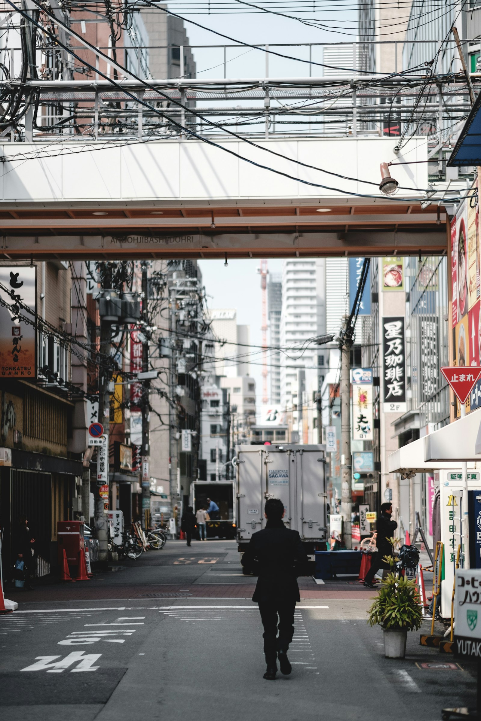 Fujifilm X-Pro2 + Fujifilm XF 56mm F1.2 R sample photo. Man walking between buildings photography