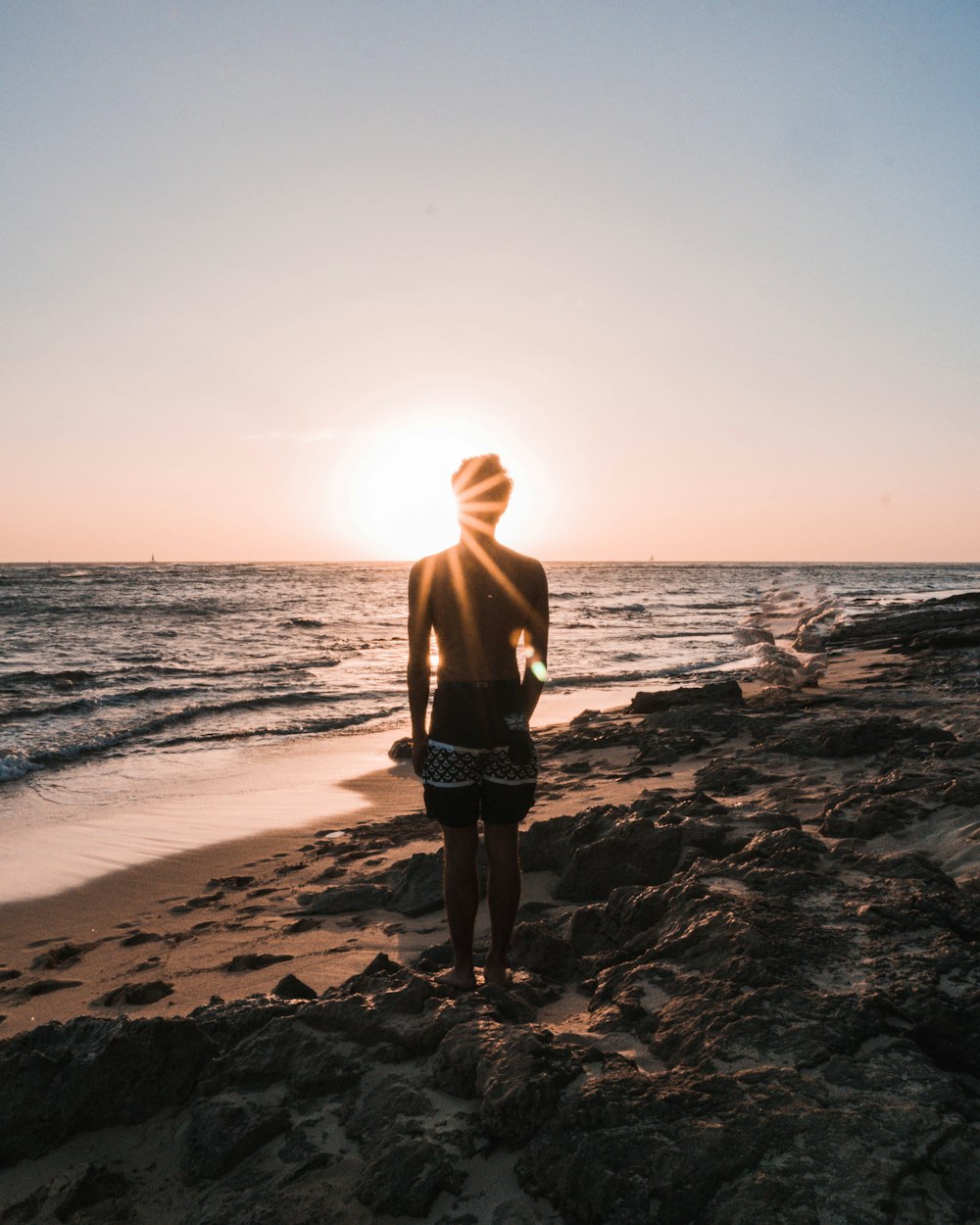 person in black shorts standing on stone