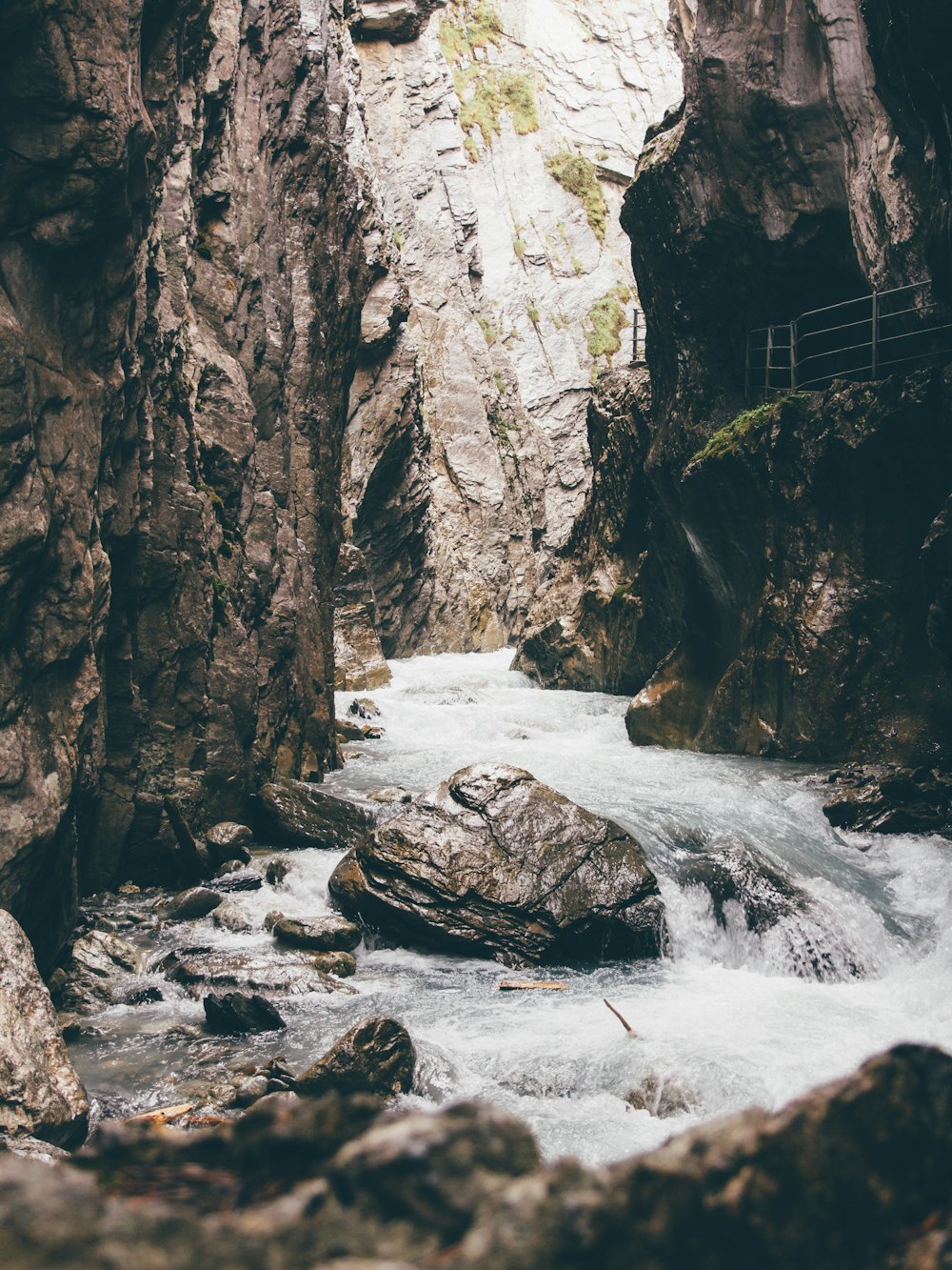 body of water beside rock formation during day time