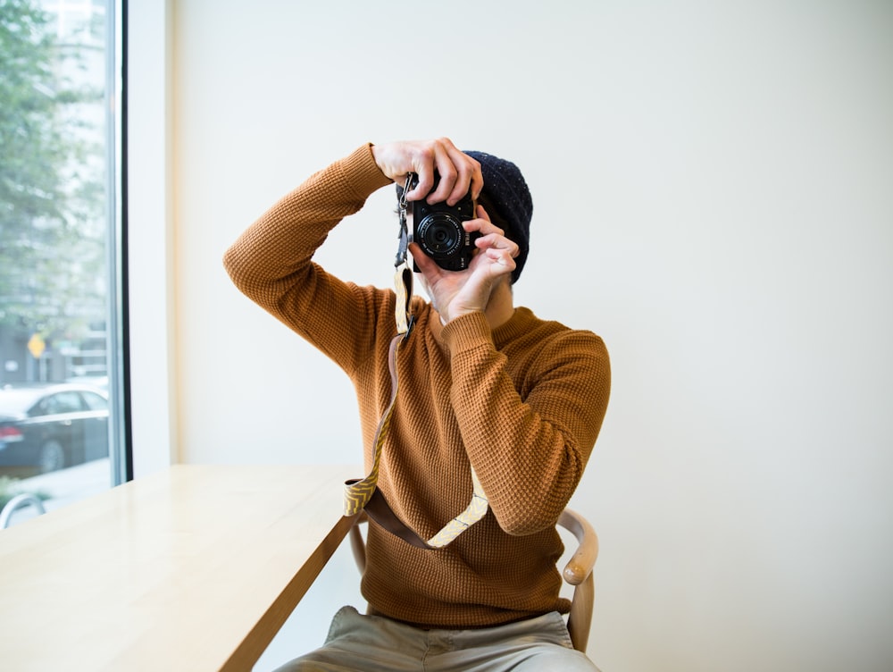 person taking a photo using DSLR camera inside room