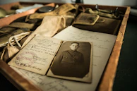 Close-up of a veteran’s hands holding medals and old photographs, telling stories of sacrifice.