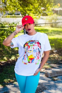 woman wearing cap, t-shirt, and teal pants during day