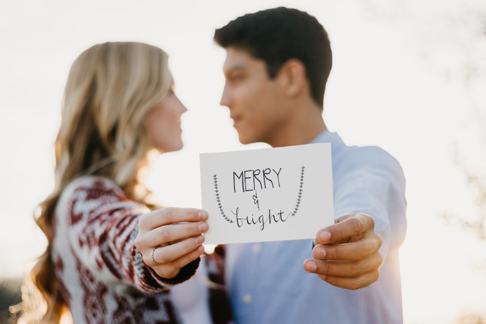 couples holding Merry & Bright card