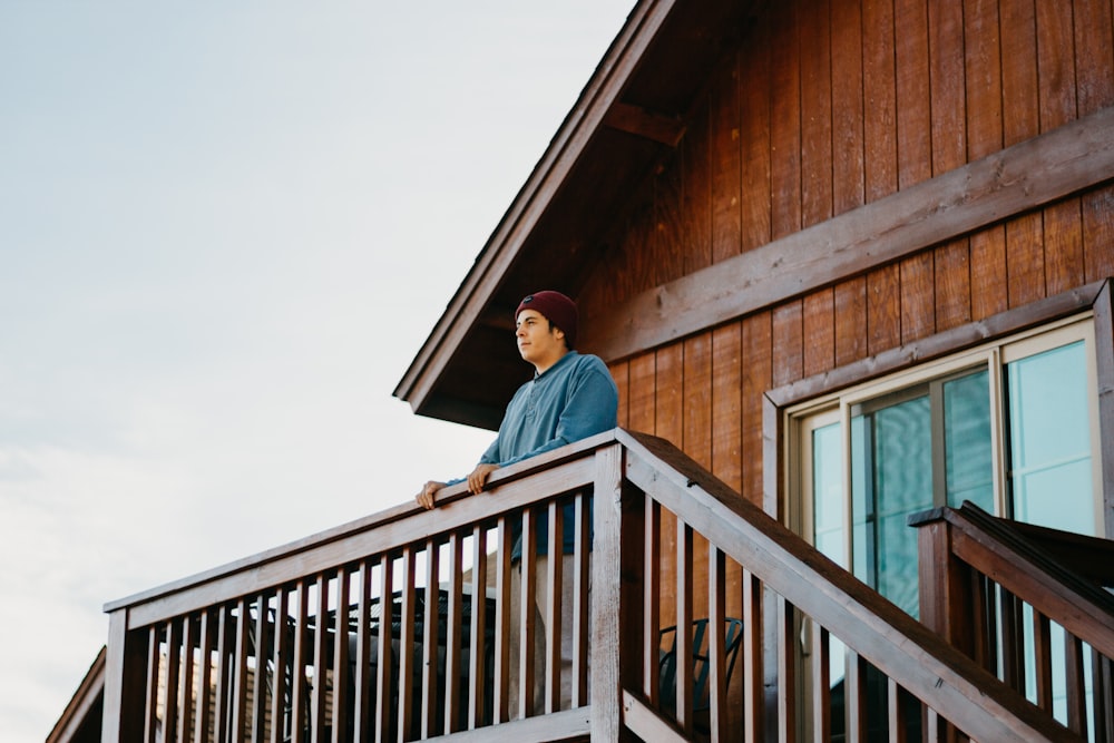 homme debout sur le dessus d’une terrasse en bois brun