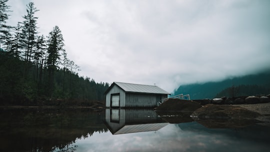 boat shed beside the lake and trees in Buntzen Lake Canada