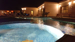 Evening view of a well-maintained pool illuminated with soft blue lighting