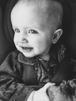 A happy parent inspecting their spotless baby car seat after cleaning service.
