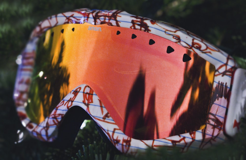 shallow focus photography of pink, orange, and green snow goggle