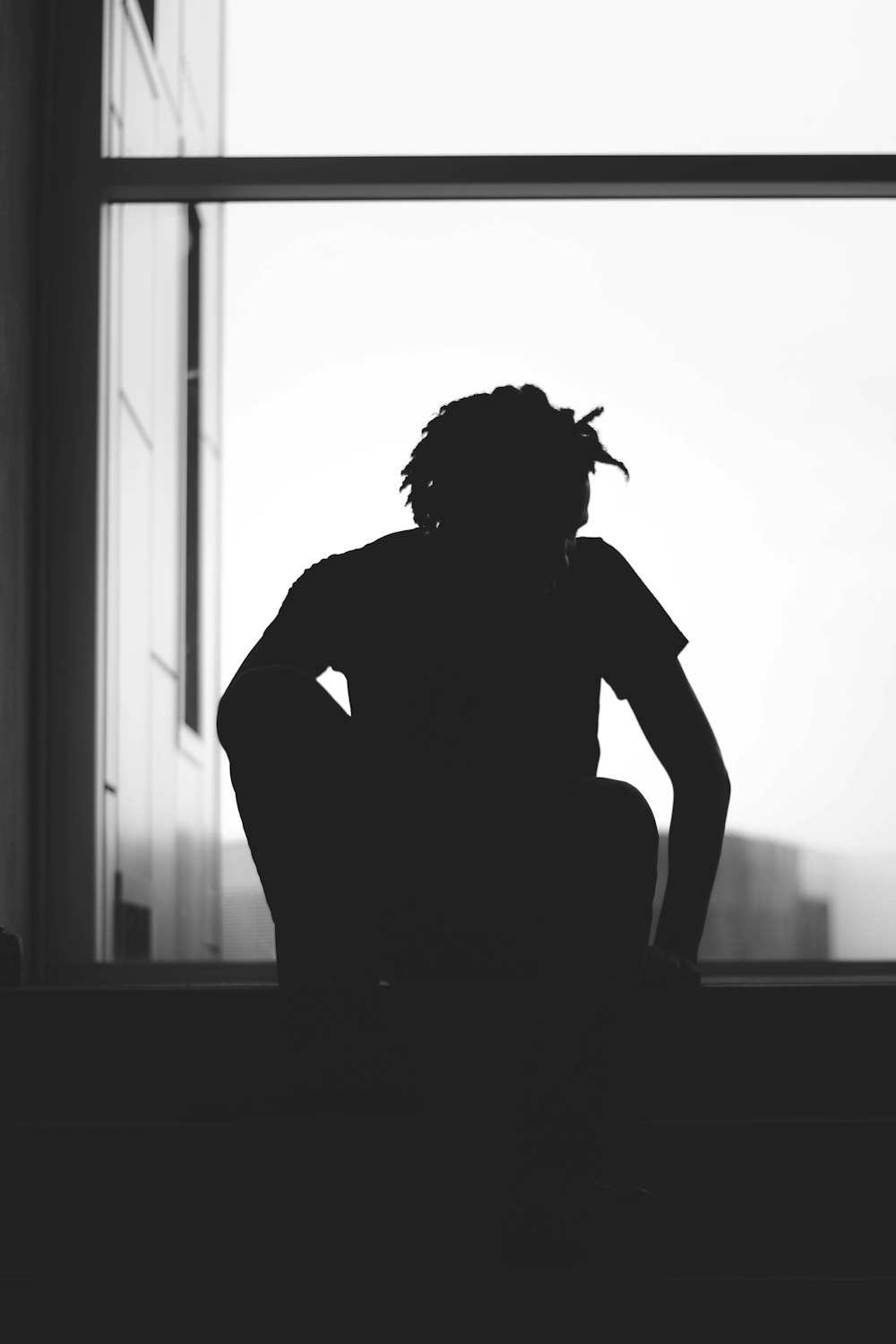 silhouette of a person sitting near window