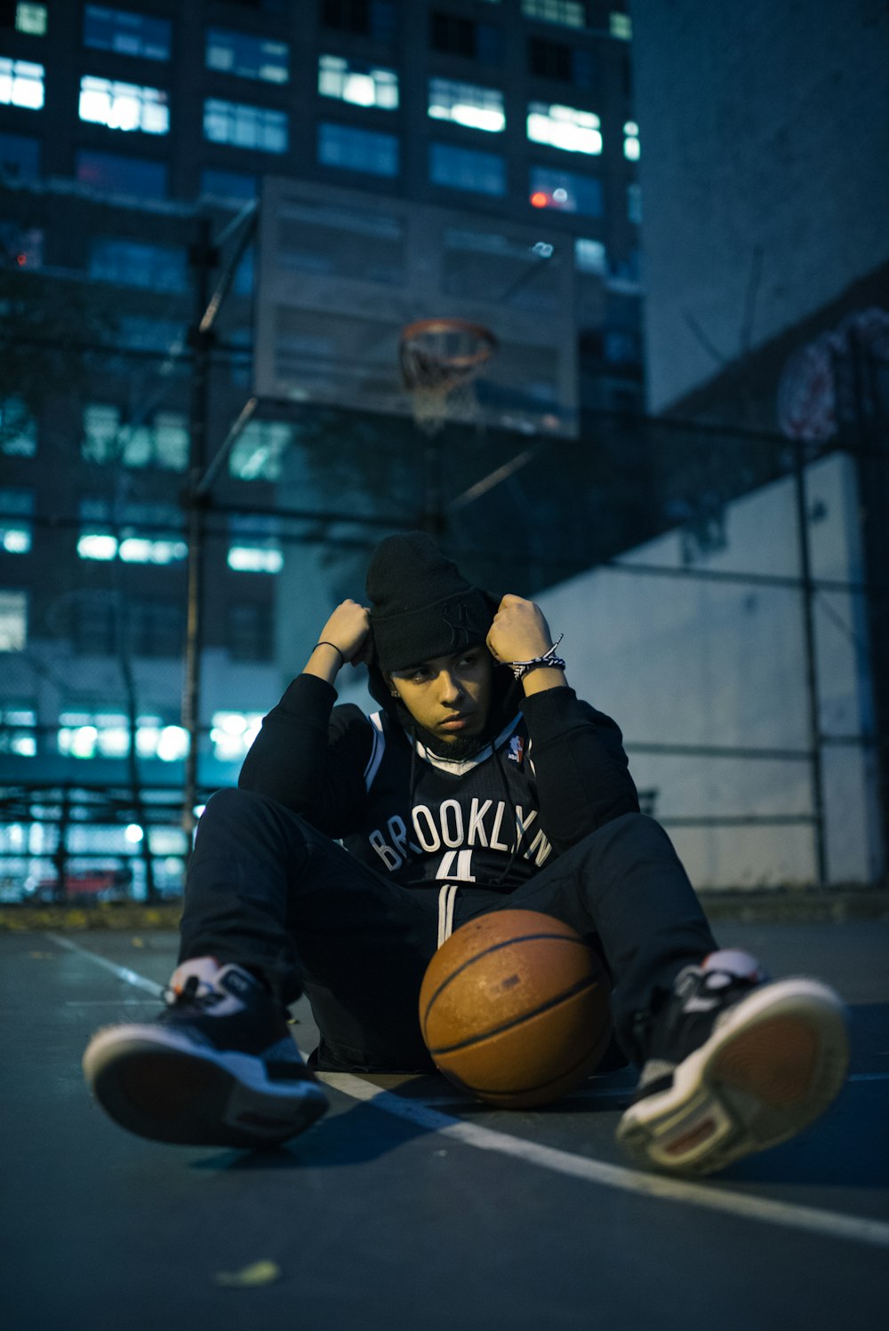 man sitting on basketball court