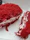 Close-up of a red velvet pastry on a delicate plate with a gold fork beside it.