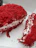 Close-up of a red velvet pastry on a delicate plate with a gold fork beside it.