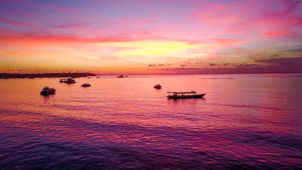 Barcos en el cuerpo de agua durante la puesta del sol