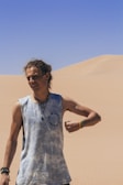 Lifestyle shot of a person wearing layered macramé jewelry, standing against a backdrop of Mexican desert plants.