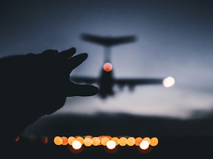 silhouette photo of airplane landing on airline