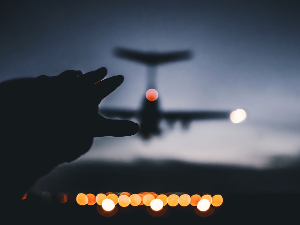 silhouette photo of airplane landing on airline