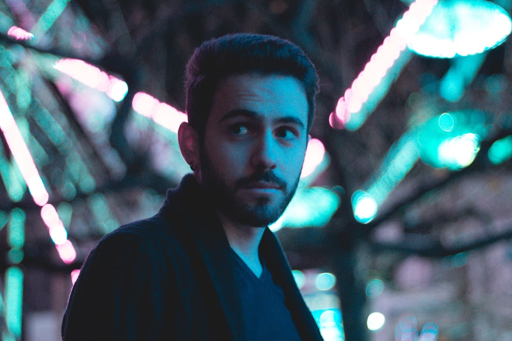 man standing near fluorescent lights during nighttime