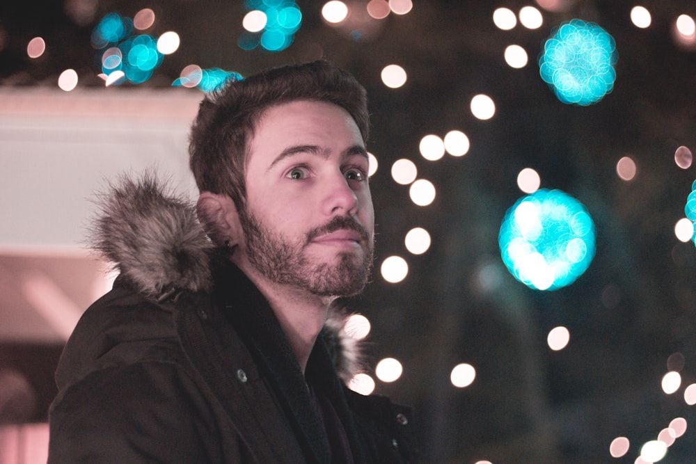 bokeh photography of man wearing parka jacket