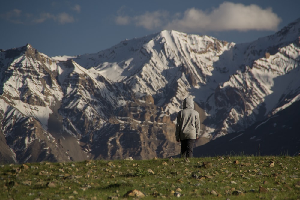 man standing looking at tundra mountain